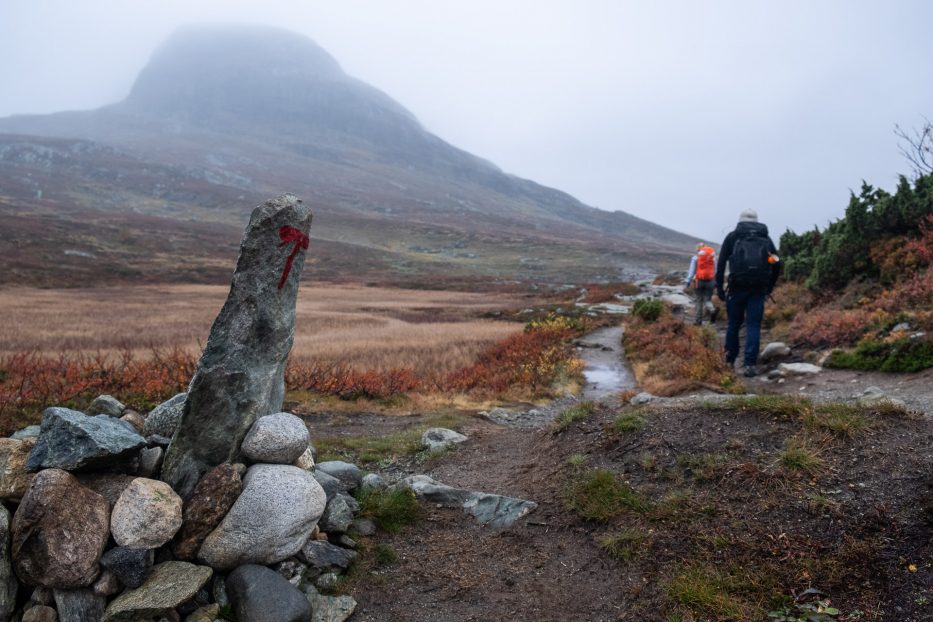 two people hiking mount bitihorn with autumn colors and loads of fog