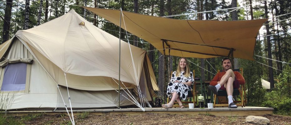 mann og kvinne sitter utenfor telt på glamping hos Breiva gjestegård i Norge 