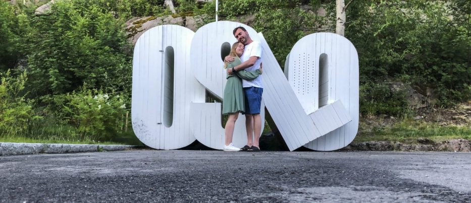 Man and woman hugging in front of installation which says OSLO