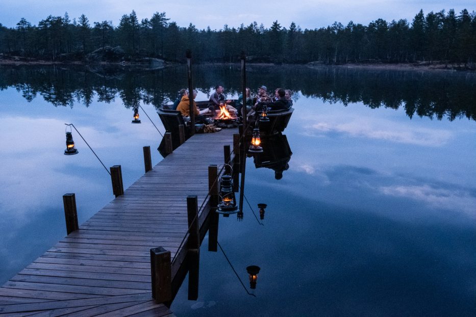 Koselig kveldsstemning rundt bålpanne på brygge hos Canvas Telemark