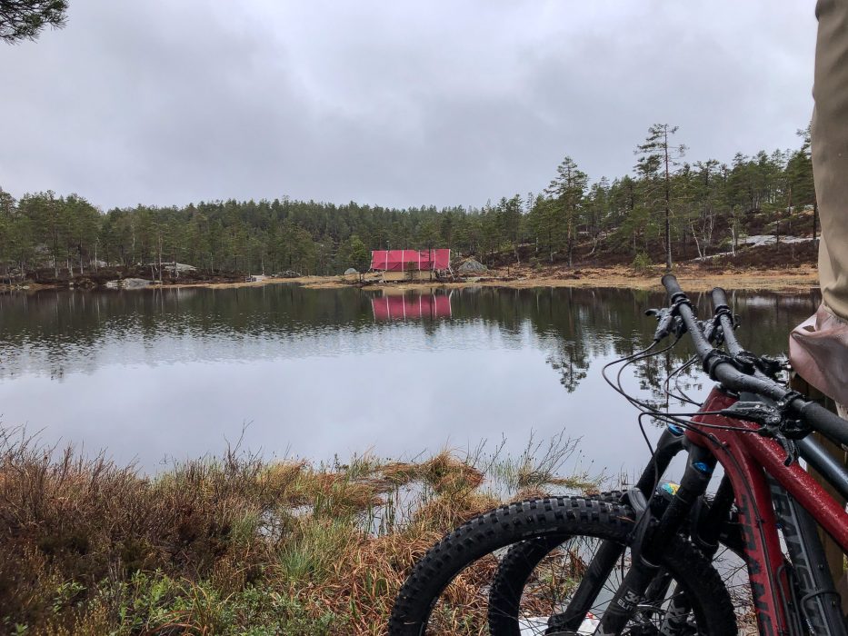 To sykler i front av vann med rødt hus i bakgrunnen hos Canvas Telemark