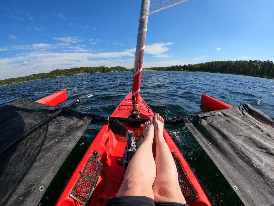 Person sitting on a red trimaran out on the sea