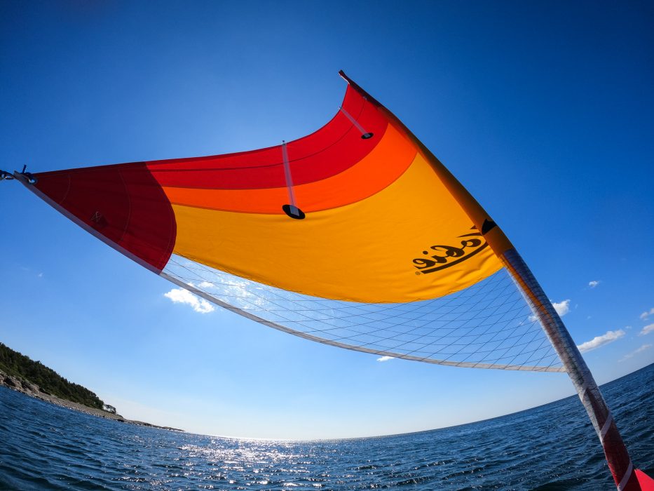 the sail of a trimaran blowing in the wind