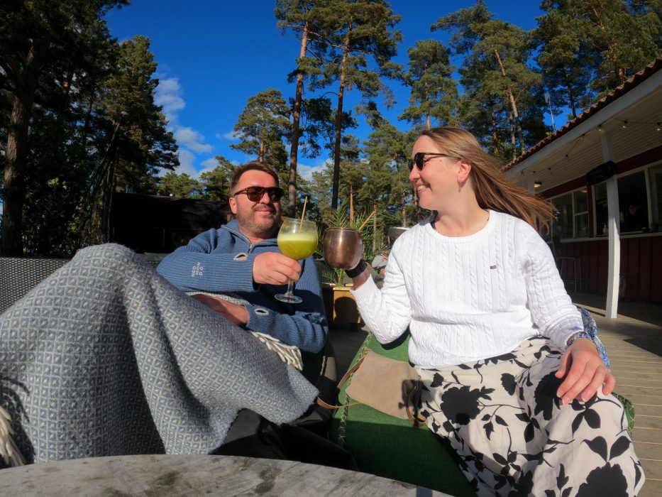 man og kvinne sitter ute og tar en skål i sola hos canvas hove