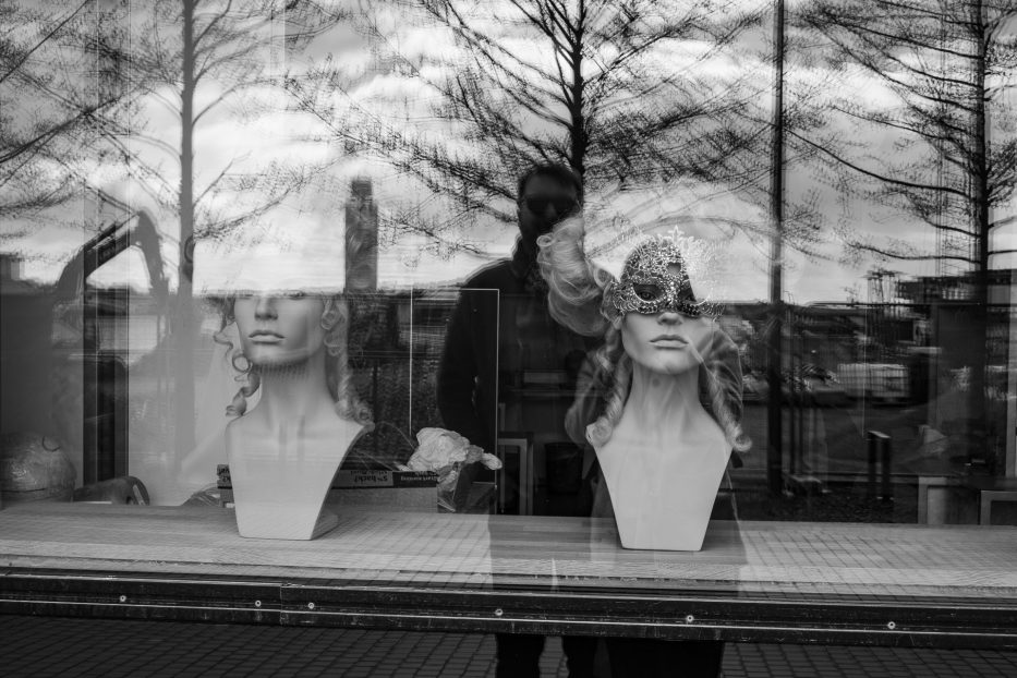 reflection of two people in the Oslo Opera House window with costumes on the inside