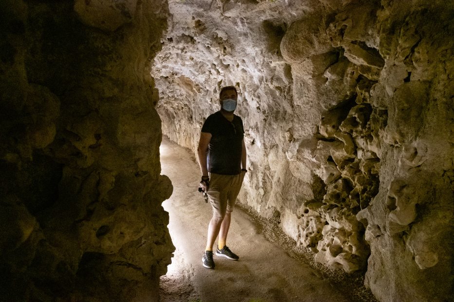 man with a face mask inside the underground walkway at Quinta da Regaleira