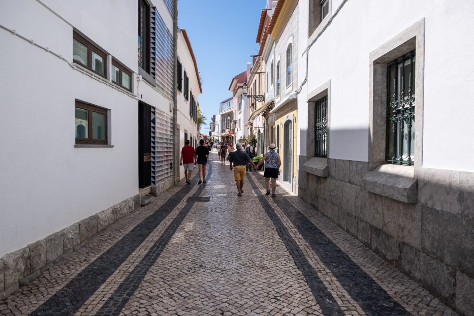 people walking in the cobblestone pedestrian area of Cascais