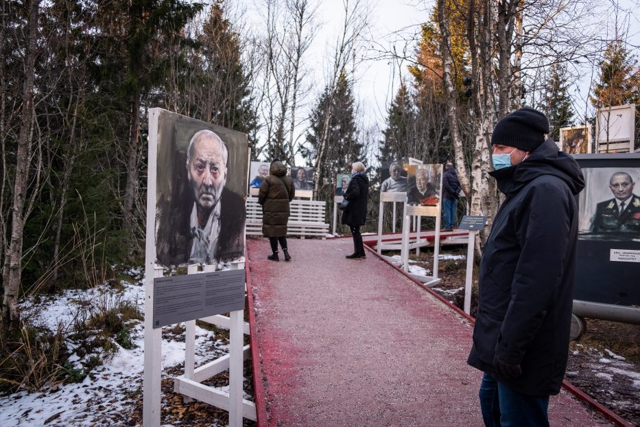 man wearing a face mask watching a painting of a man at roseslottet