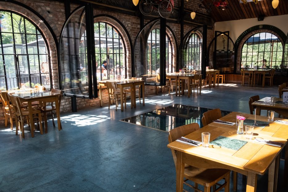 the inside of a restaurant with large windows and the sun shining inside