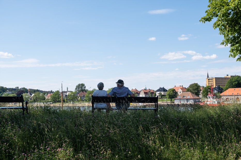 woman and man enjoying the view over fredrikstad from a bench