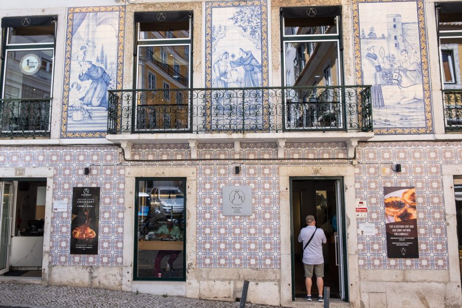 mag walking inside a bakery with pastel de nata in lisbon