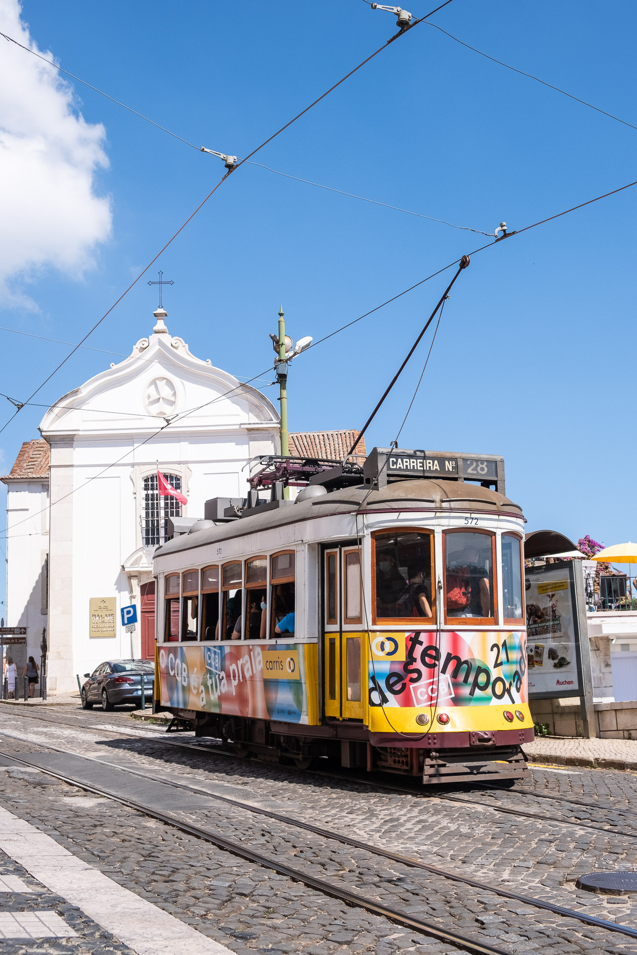 trikk nr 28 passerer en kirke i lisboa