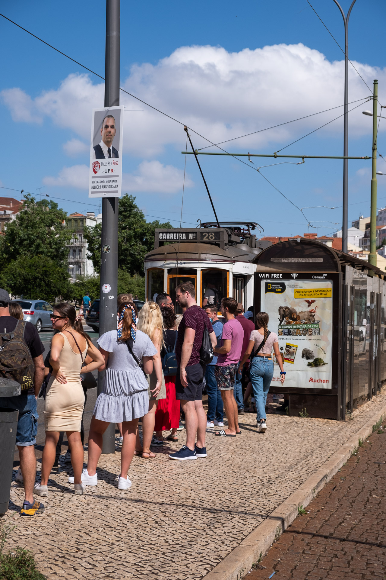 mennesker venter i kø for å kjøre trikk nr 28 i lisboa