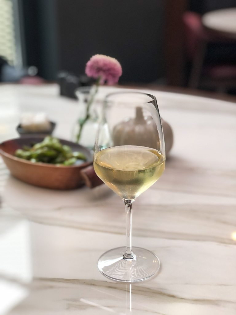 a glass of txakoli on a table