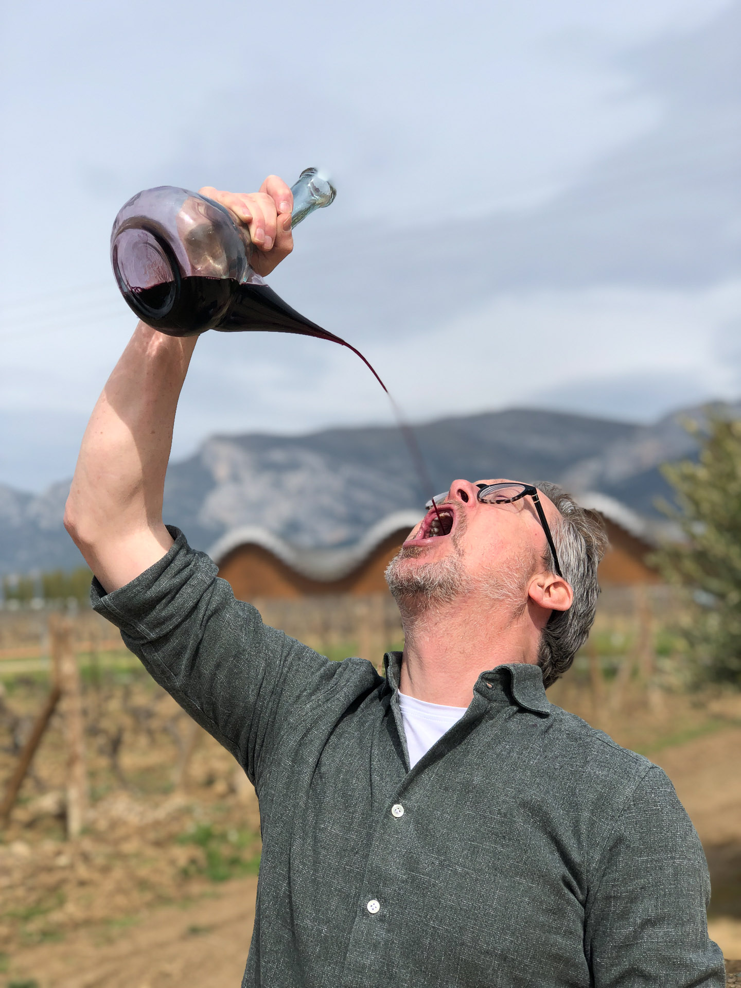 mann drikkere vin rett ut av karaffel hos Javier san pedro winery in rioja alavesa