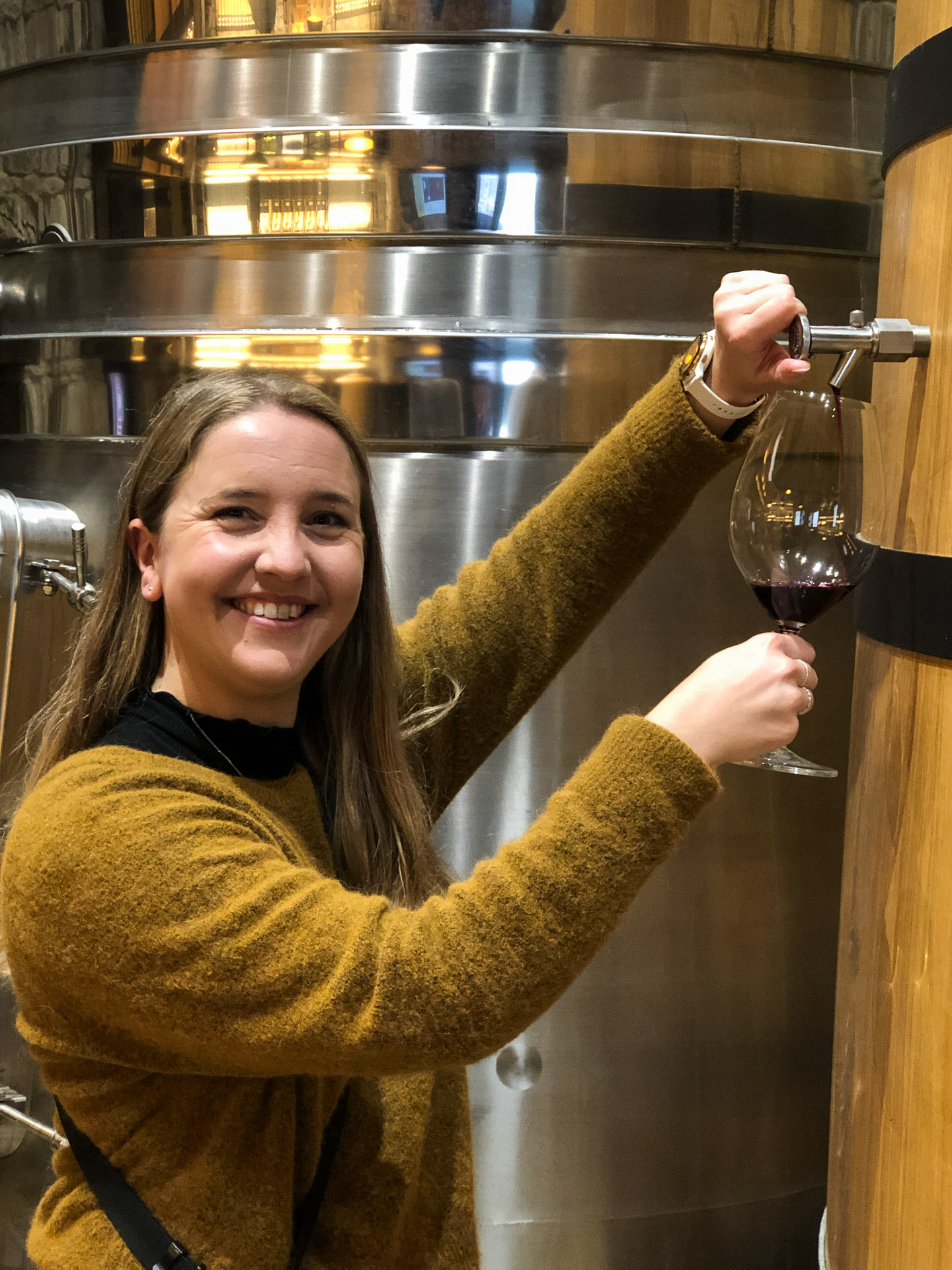 woman pouring wine out from a wine barrel in Rioja Alavesa