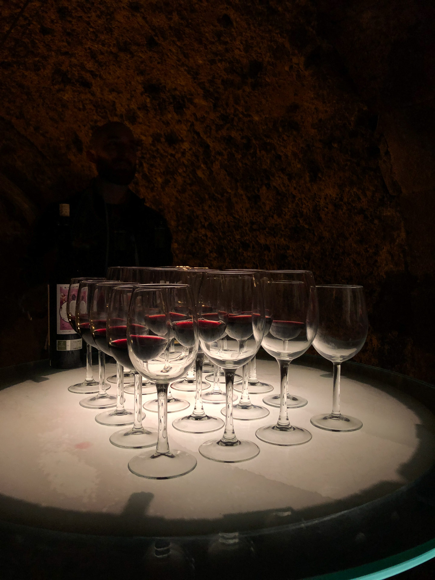 wine glasses lit up from below while standing on a wine barrel