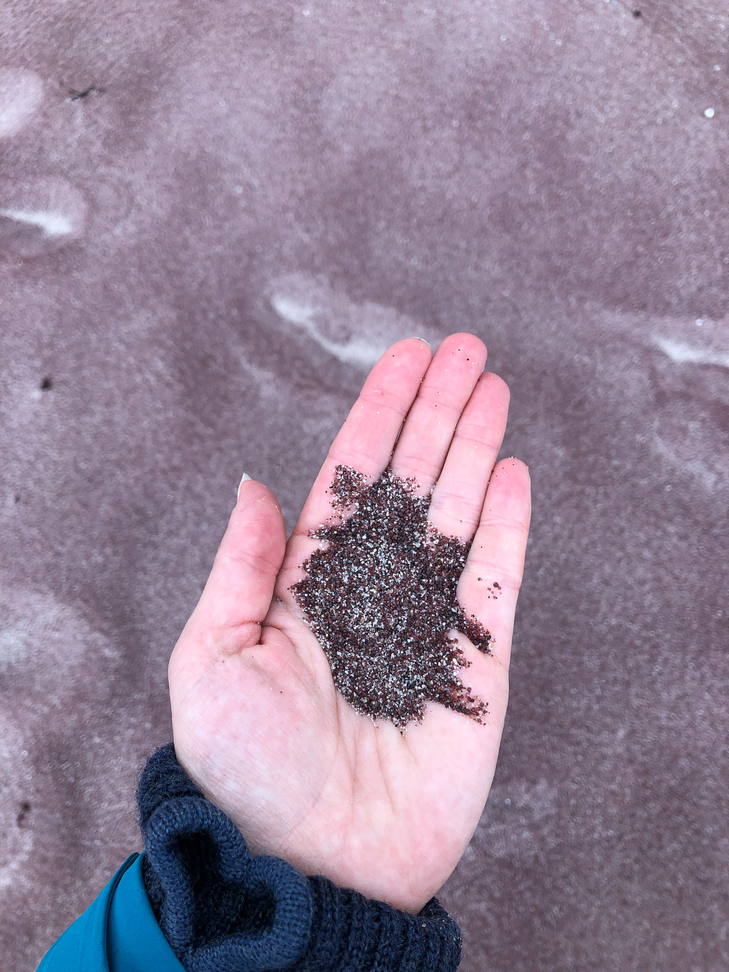 pink sand in a hand