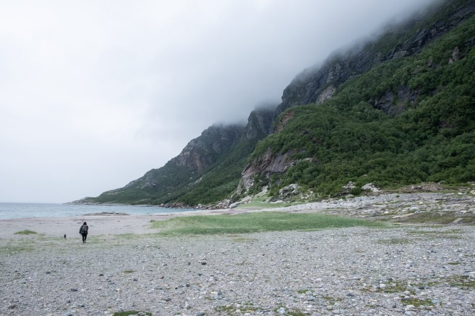 person vandrer på stranda Mjelle i Bodø med skyer som ruller inn over fjellet