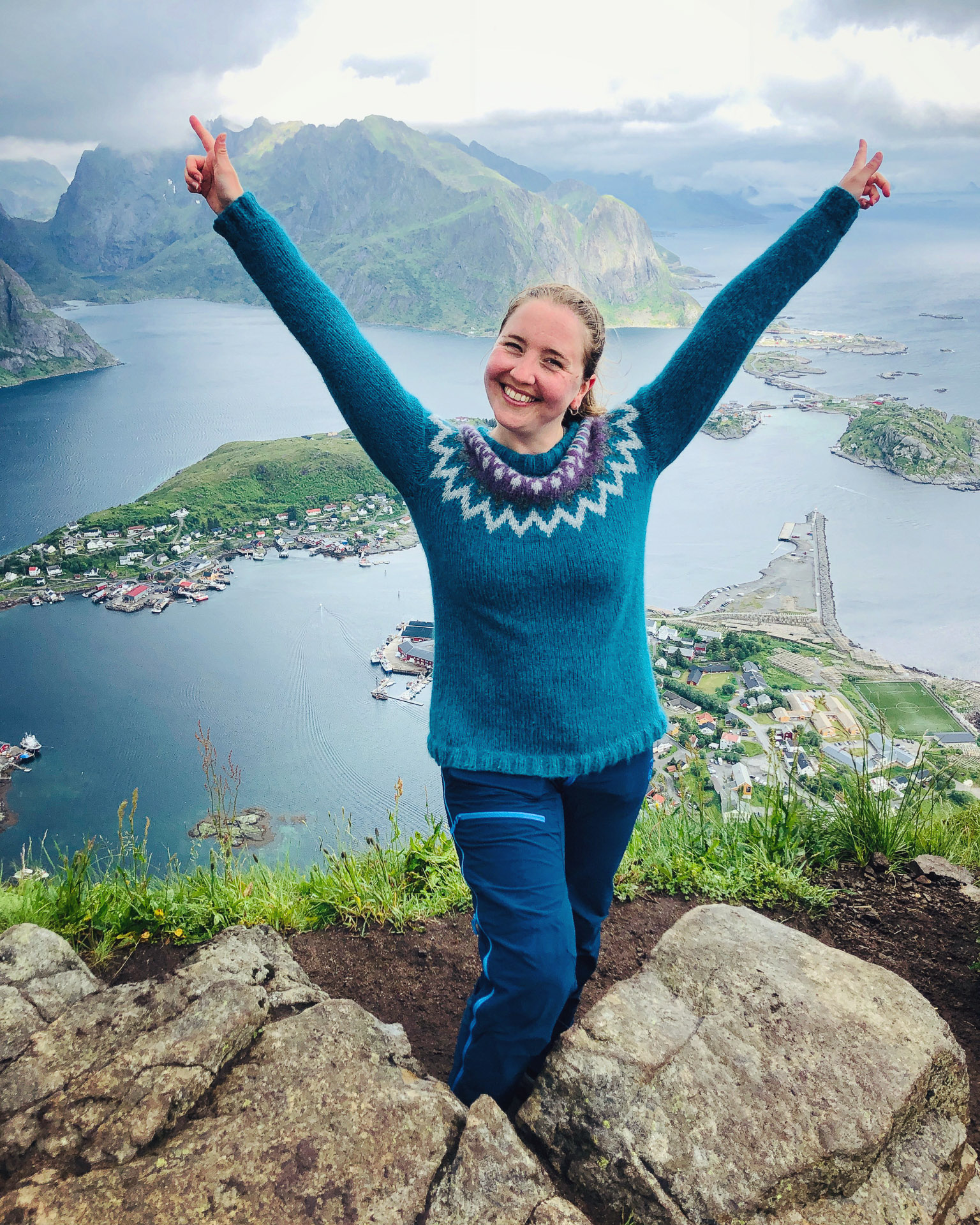 smilende kvinne fra toppen av reinebringen i lofoten