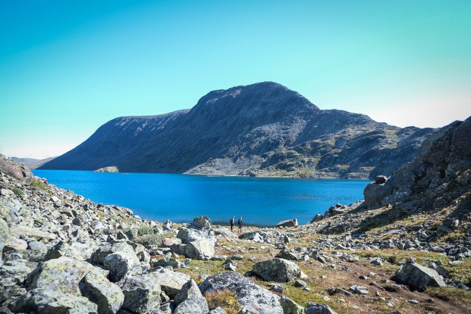 view of besseggen in front of a lake