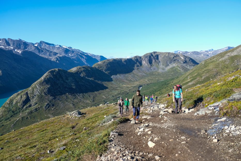 mennesker ute på fjelltur i norsk natur badet i sol