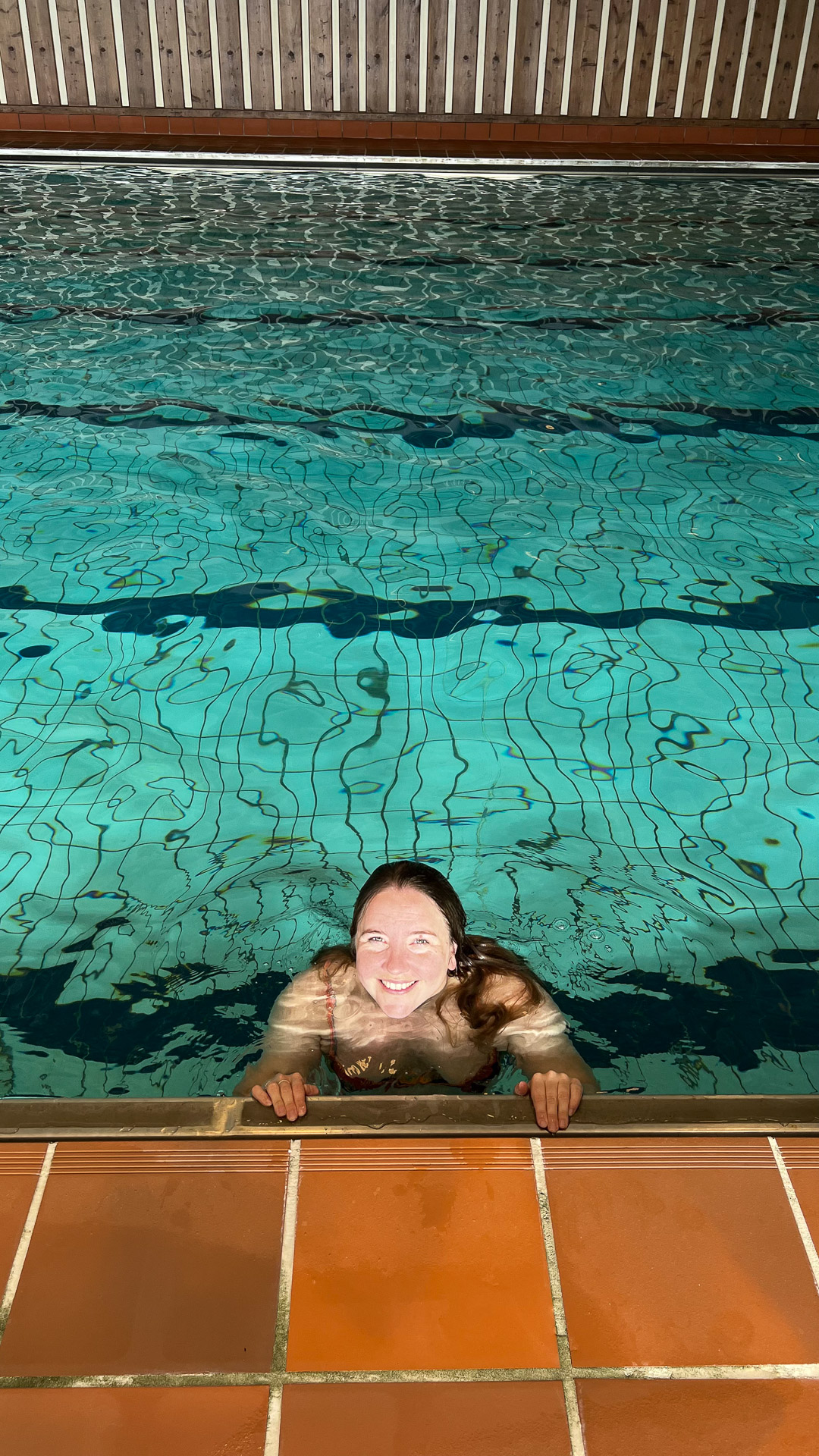 en kvinne smiler i et svømmebasseng