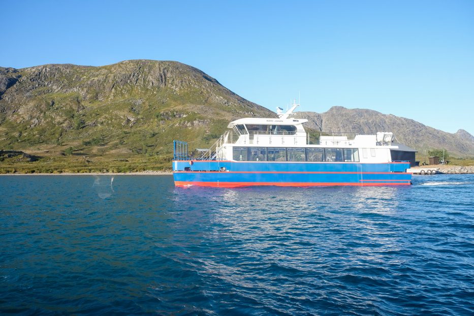 a ferry on a lake in front of mountains