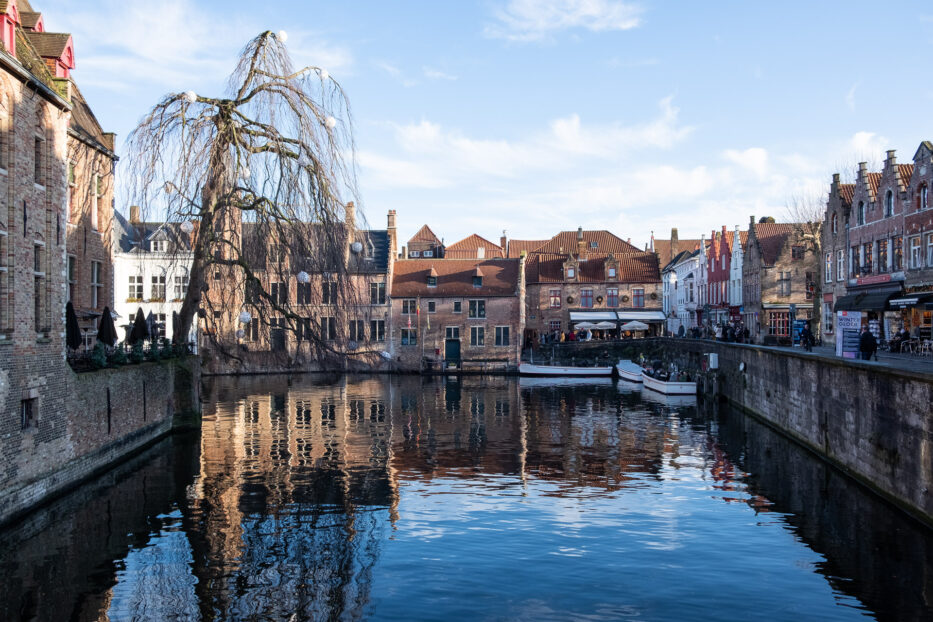 the canal of bruges bathed in sunlight with reflections in the water