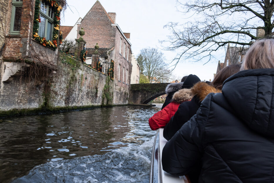 people inside a boat on the canal of bruges