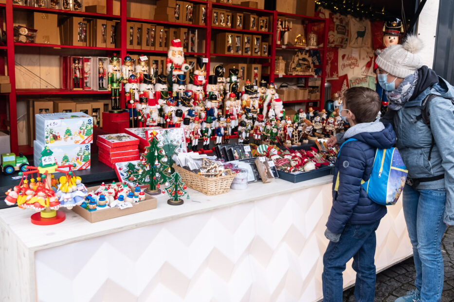 to personer ser på julepynt i en bod på julemarkedet i brugge