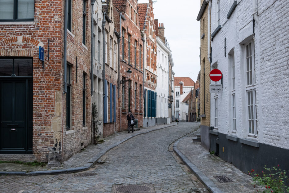 person walking in a cobble stone street in bruges