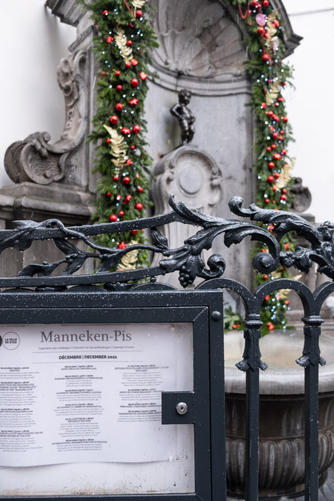 sign of manneken pis and the statue all dressed up for christmas