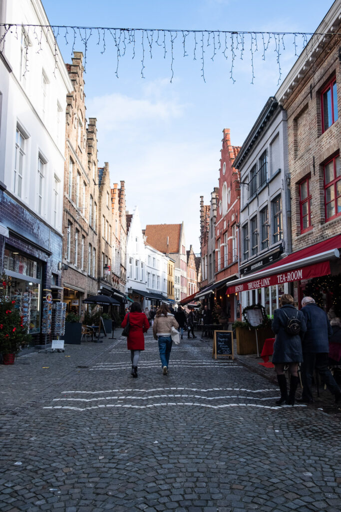 mennesker går gjennom en julepyntet gate i brugge