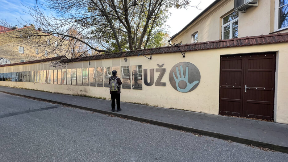 a man standing in front of the independent declarations in uzupis vilnius lithuania