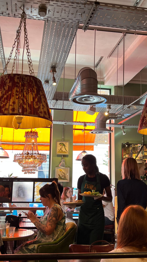 a waitress serving food at a bill's restaurant in london