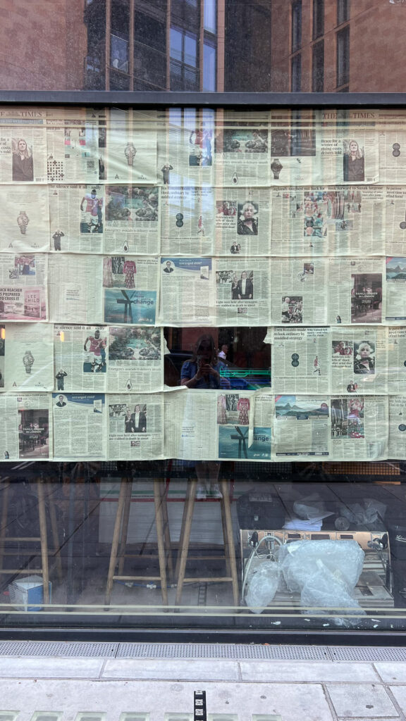 a shop front closed off with newspapers in london