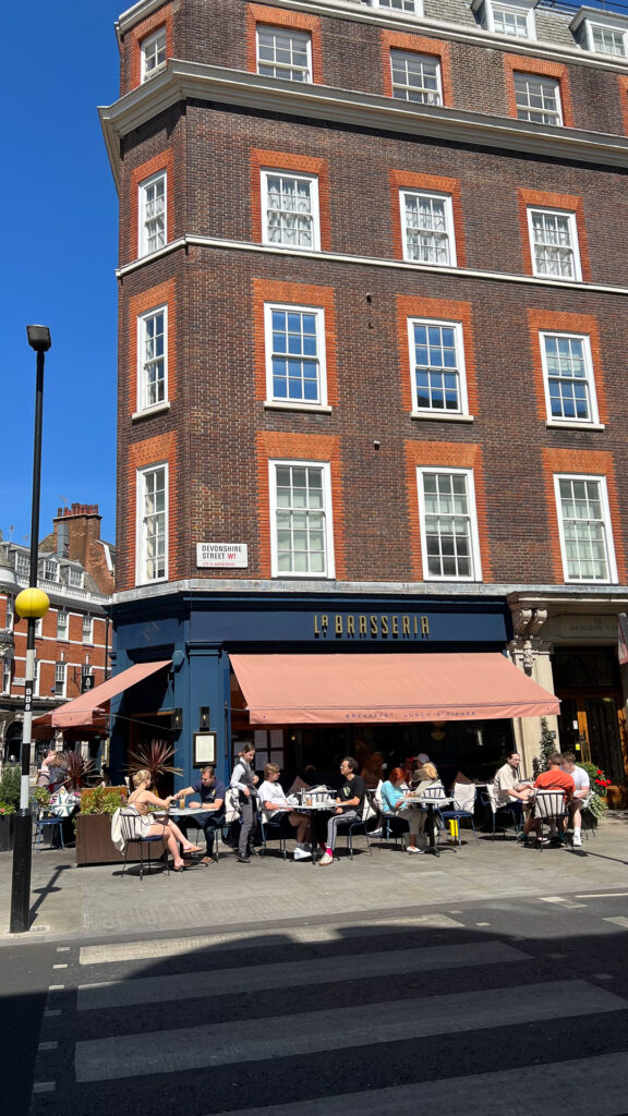 people eating outside in the sun at la brasseria in london