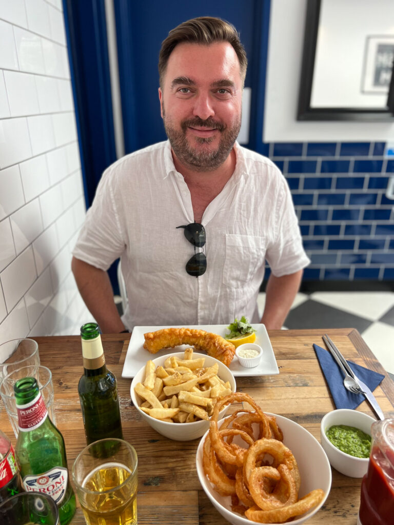 smilende mann foran glutenfri mat hos hobson's i london