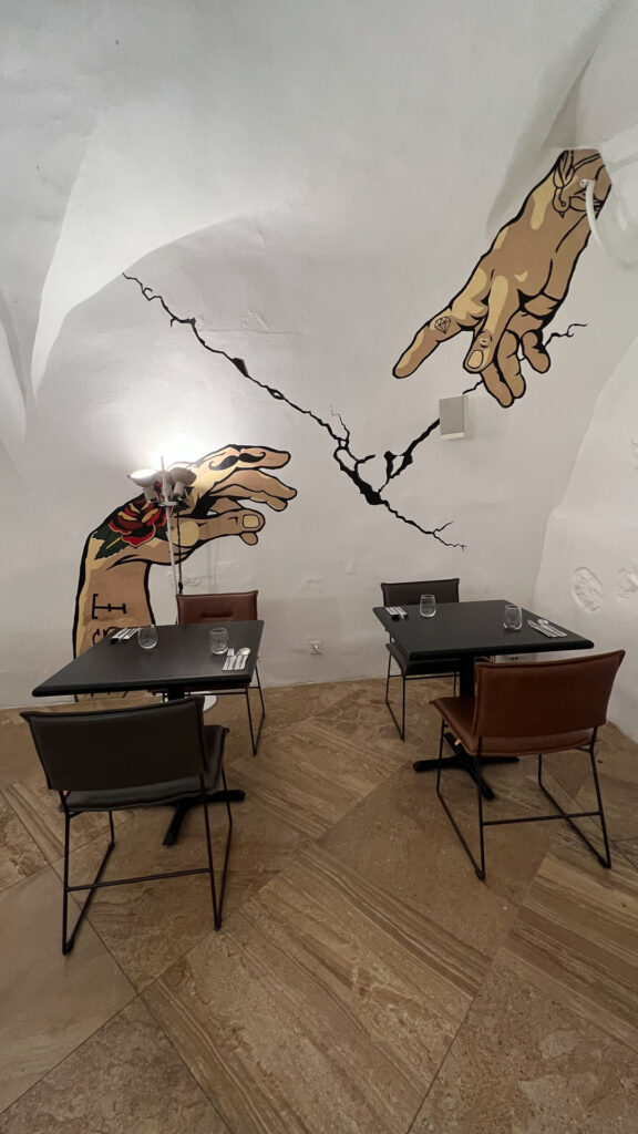the dining area at hotel artagonist with huge wall painting and two tables with chairs