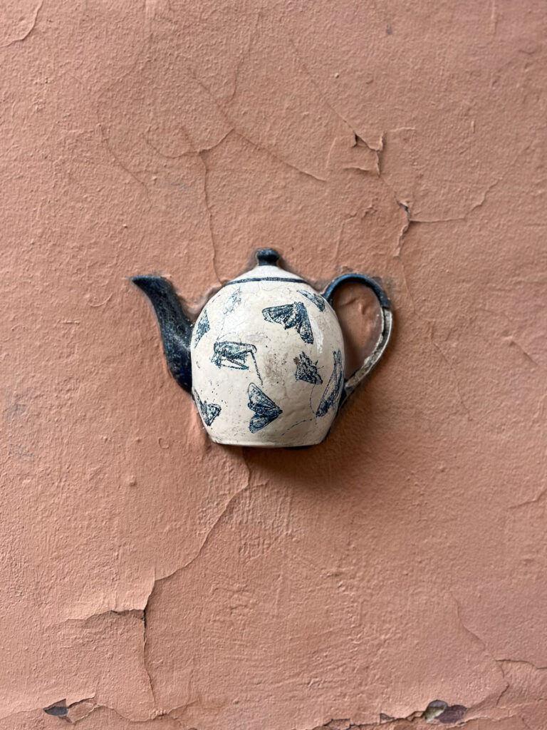 art detail of a tea pot on a wall in vilnius