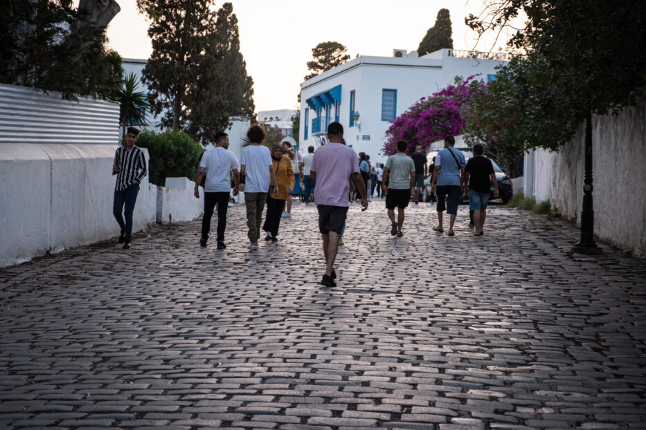 personer går gatelangs i solnedgangen i sidi bou said