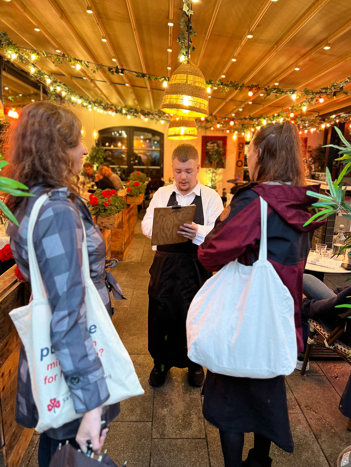 two women talking to a waiter outside restaurant gro in örebro