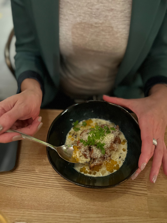 woman holding spoon and bowl with a dish with corn