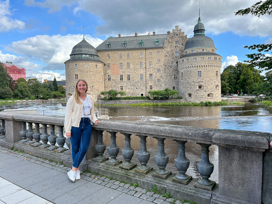 smiling woman in front of örebro castle