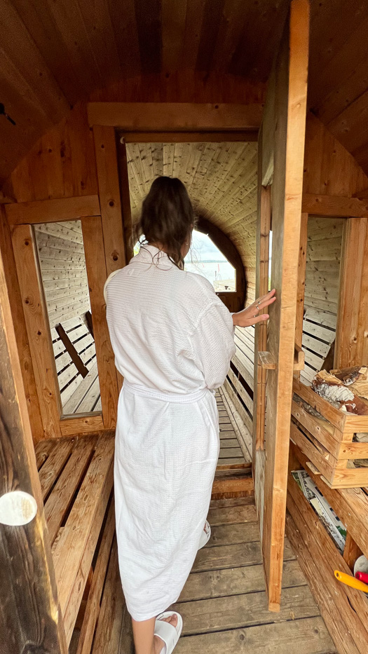 woman wearing white robe entering the sauna at Katrinelund Gästgiveri & Sjökrog