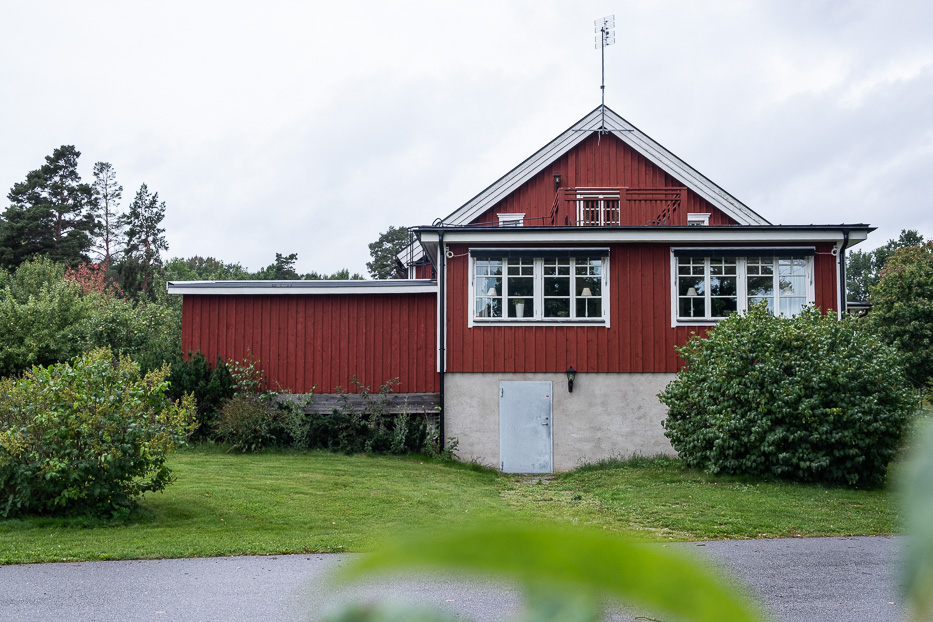 outside the main building at Katrinelund Gästgiveri & Sjökrog a red house with green bushes around