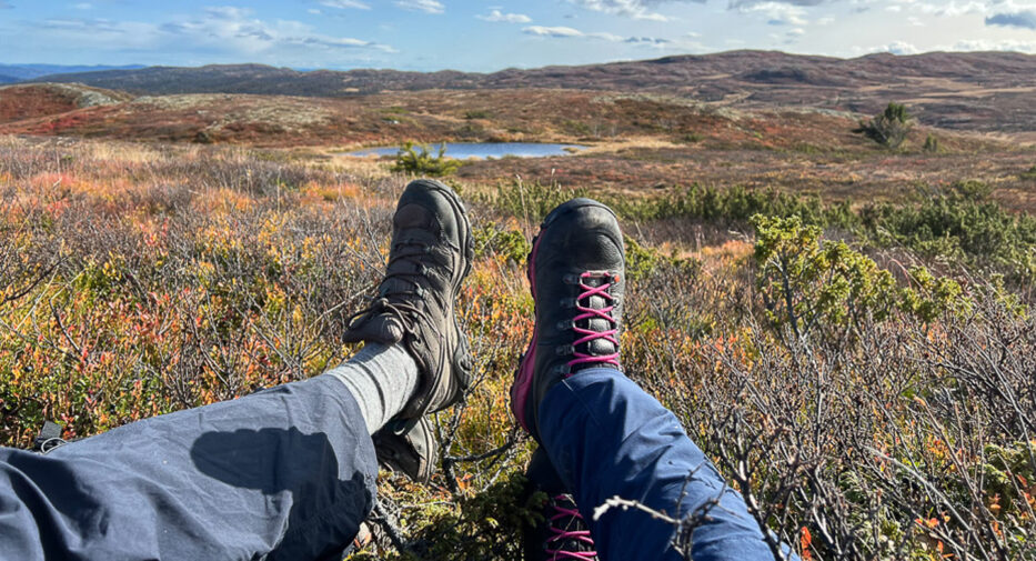 two pair of feet relaxing in autumn colours in the mountains